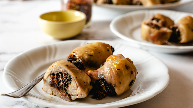 sliced chicken thighs on plate with more in background