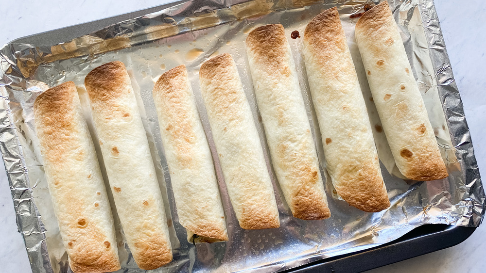 baked taquitos on foil lined baking sheet