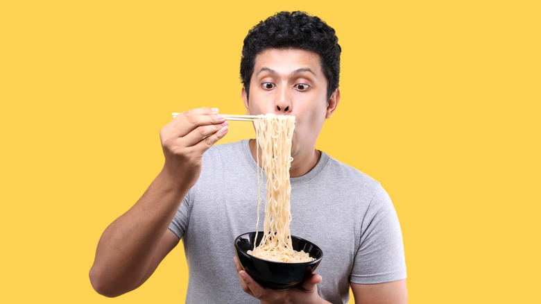 Man pulling a long string of ramen 