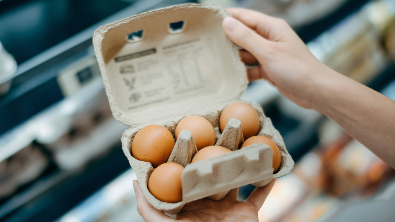 Person looking at egg carton