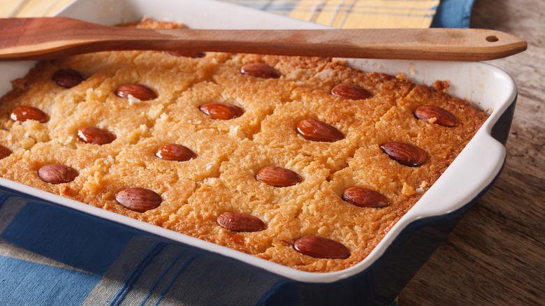 Baking dish of basbousa with wooden spoon