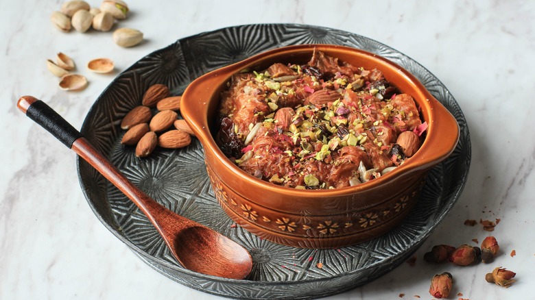 A bowl of om ali with crushed nuts on top