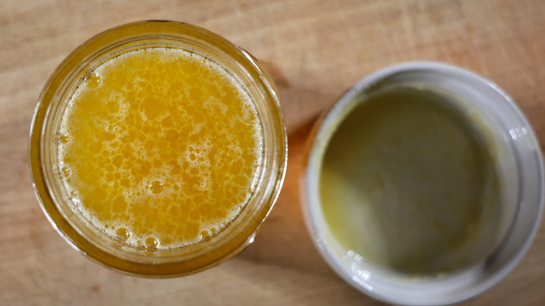 overhead view of a jar of whiskey and melted butter with an empty ramekin beside it