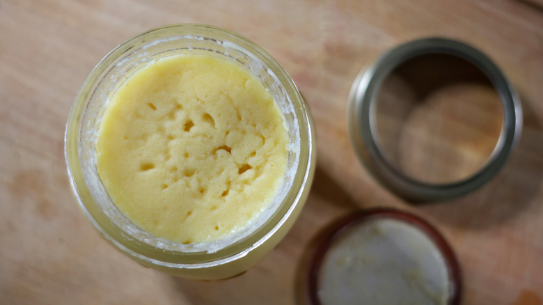 overhead view of a jar with a solid car up butter on top