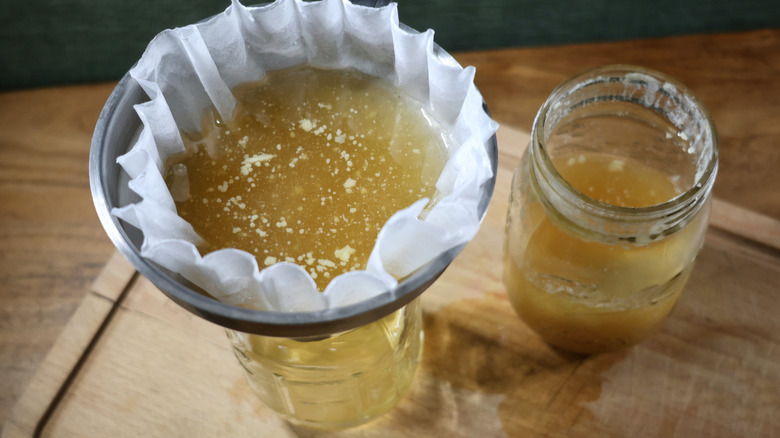 butter-washed whiskey straining through a coffee filter into a jar