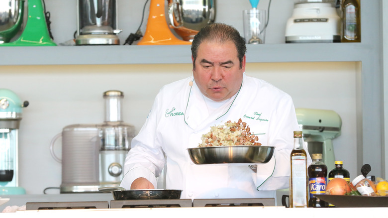 Emeril Lagasse cooking in a white coat