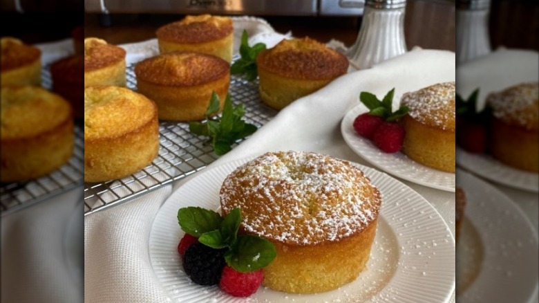 Individual olive oil cakes sprinkled with powder sugar and berries 