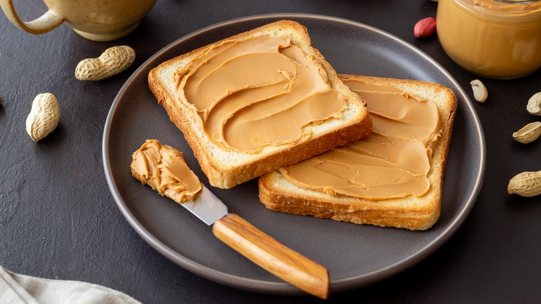 Peanut Butter spread on bread with knife