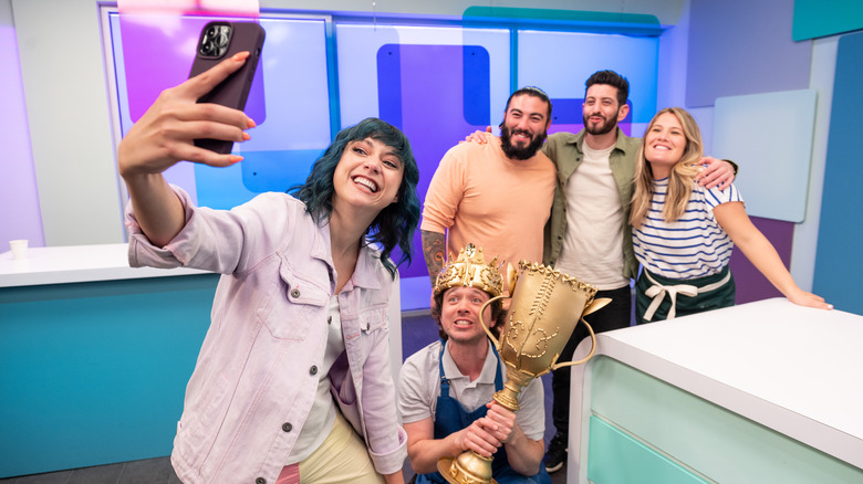 Frankie Celenza holding trophy and Katie Molinaro taking picture with contestants and judges