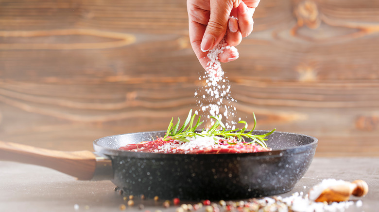 Hand using pinch of salt on dish