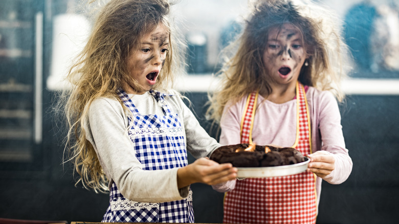 Kids holding burnt cake