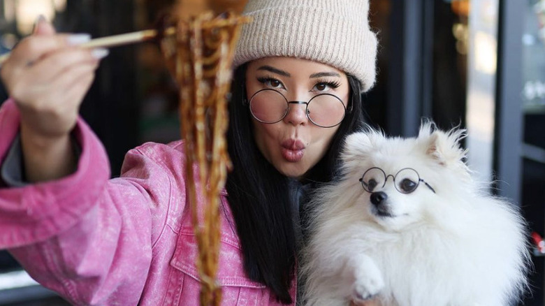 Ashley Yi with chopsticks and dog