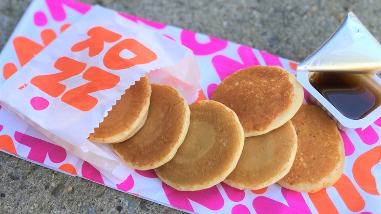 A bag of dunkin donuts pancake minis with syrup