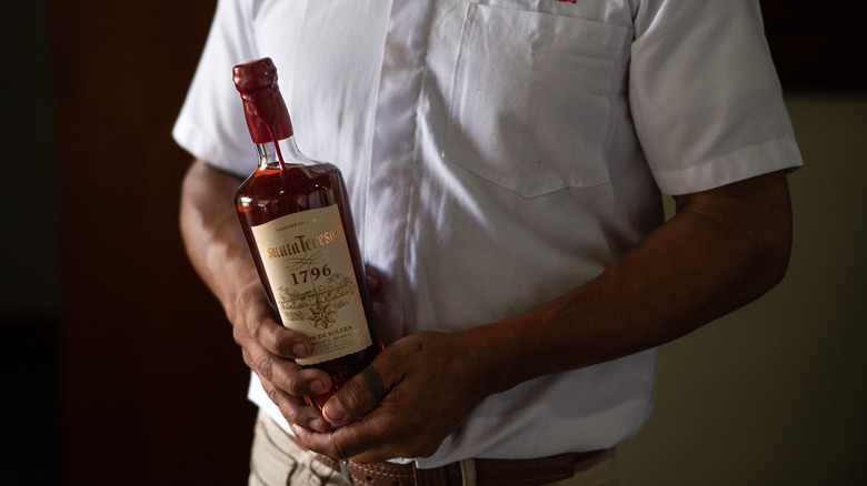 Chef holds a rum bottle