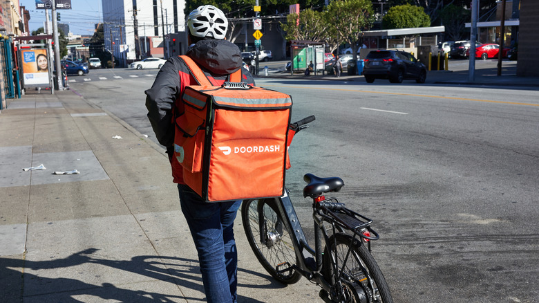 DoorDash driver pushing bike