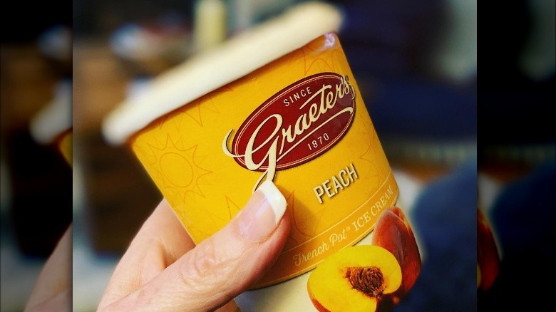 hand holding peach ice cream pint