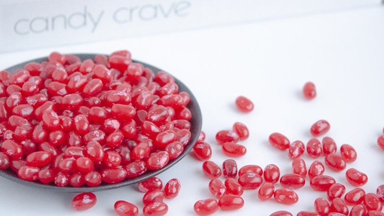 Bowl of Pomegranate jellybeans with some scattered on the side