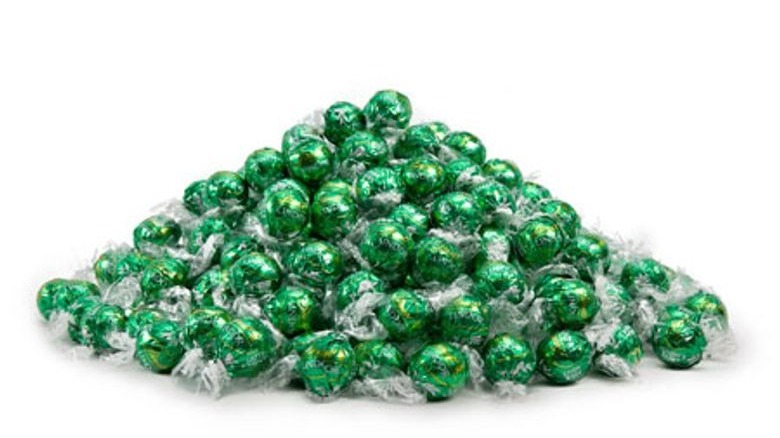 Dark green foil wrapped chocolate truffles in a pile