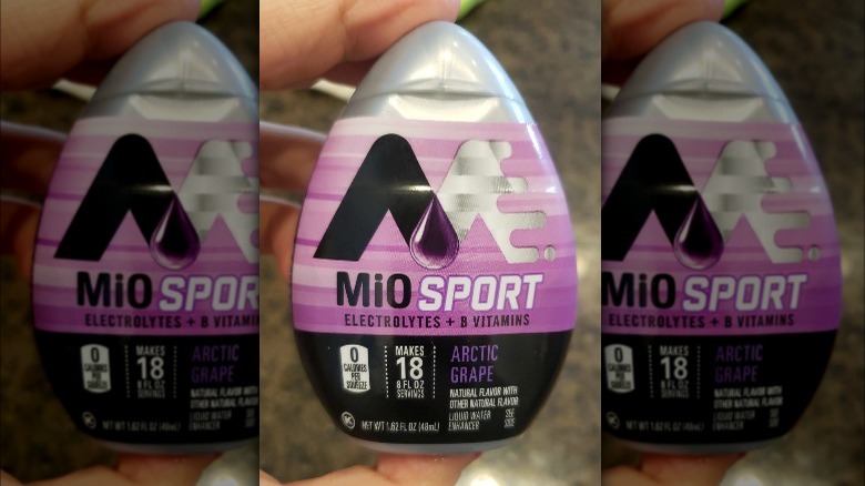 Someone holding MiO Sport Arctic Grape flavor