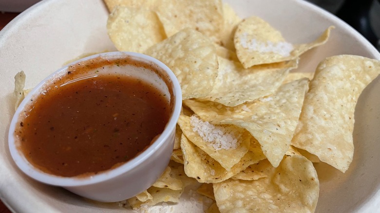 plastic cup of salsa with tortilla chips