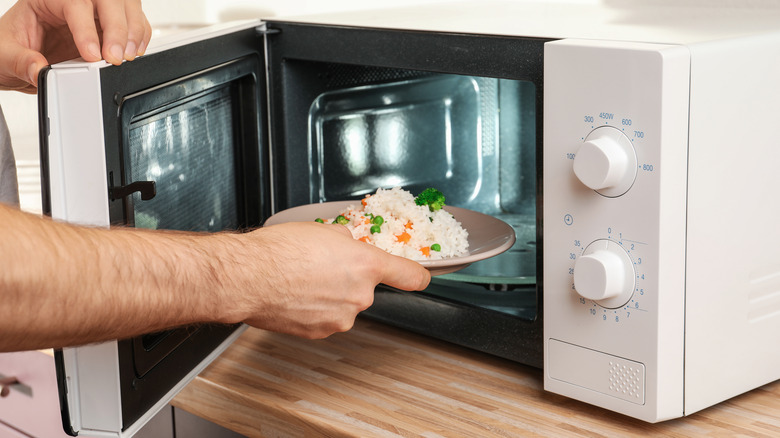 Man putting rice in microwave