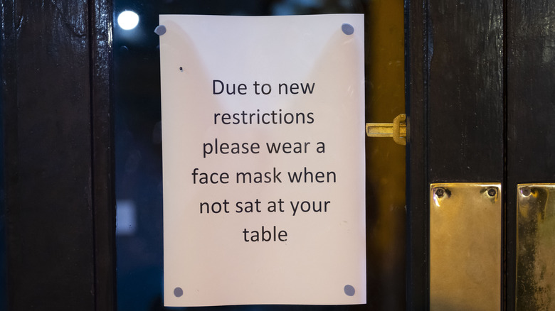 A sign explaining recent mask mandates at restaurants