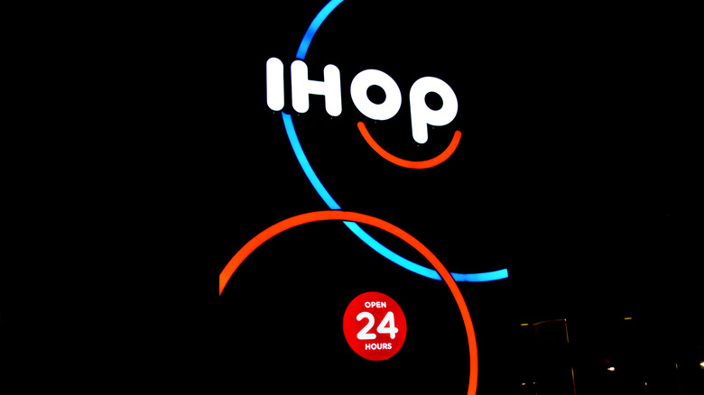 Red and blue IHOP sign at night