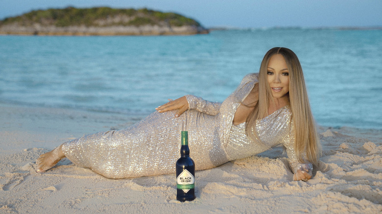 Mariah Carey with a bottle of Black Irish Original Irish Cream liqueur