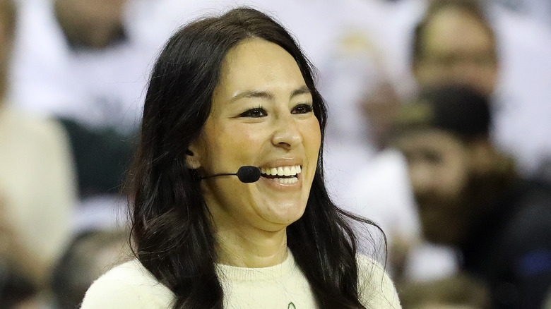 Joanna Gaines smiling with a microphone