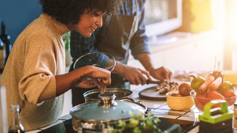 woman peering into cooking pot