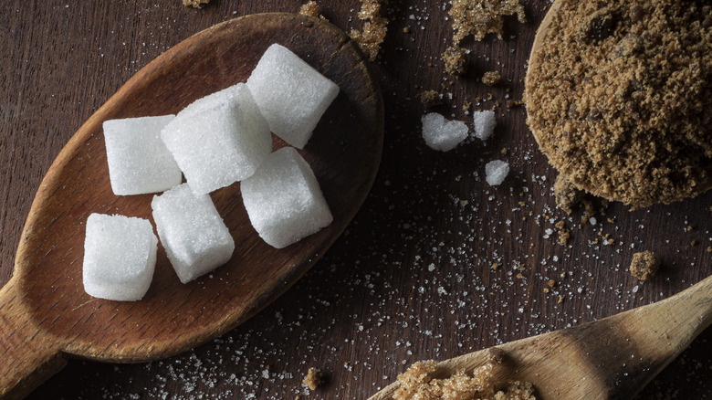 brown and white sugars on wooden spoons