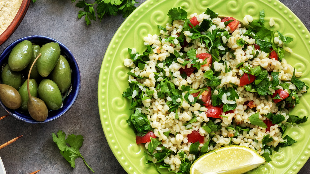 tabbouleh salad on green plate with capers