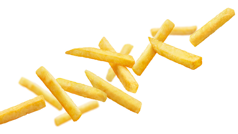 Salty french fries on white backdrop