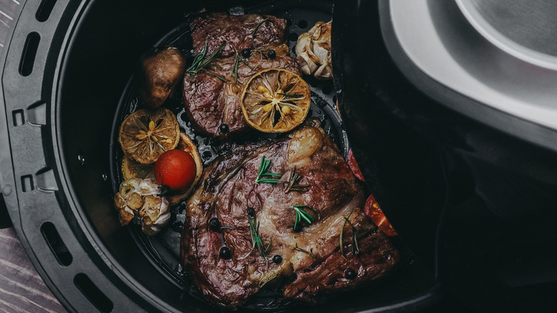 Two cooked steaks in an air fryer