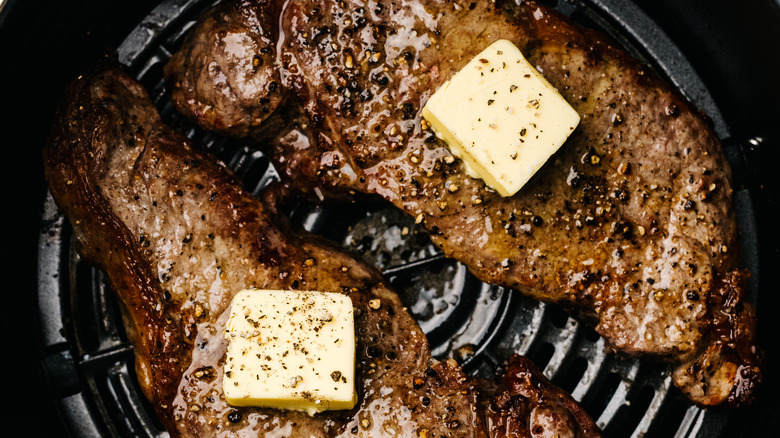 Two cooked steaks in an air fryer