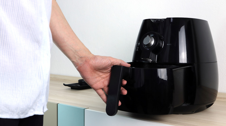 Air fryer being opened in a kitchen