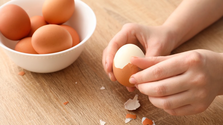Hard-boiled eggs being peeled  