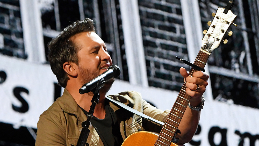 Luke Bryan playing guitar on stage