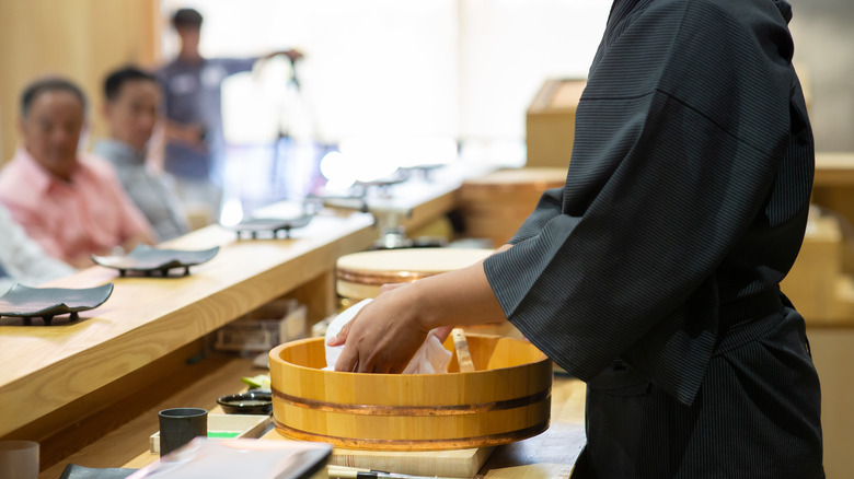 chef and customers at sushi bar