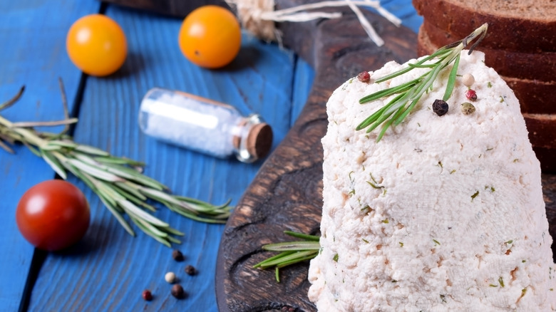 mound of bryndza cheese with rosemary and tomatoes