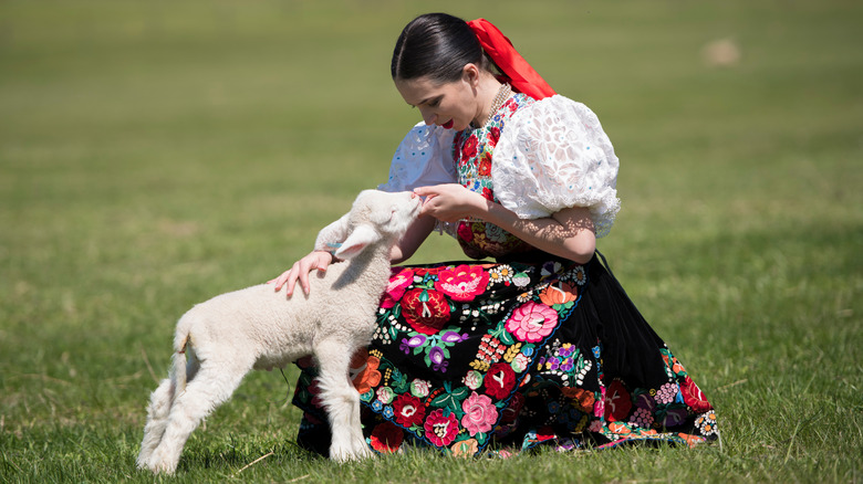 woman in Slovakian national costume with a lamb