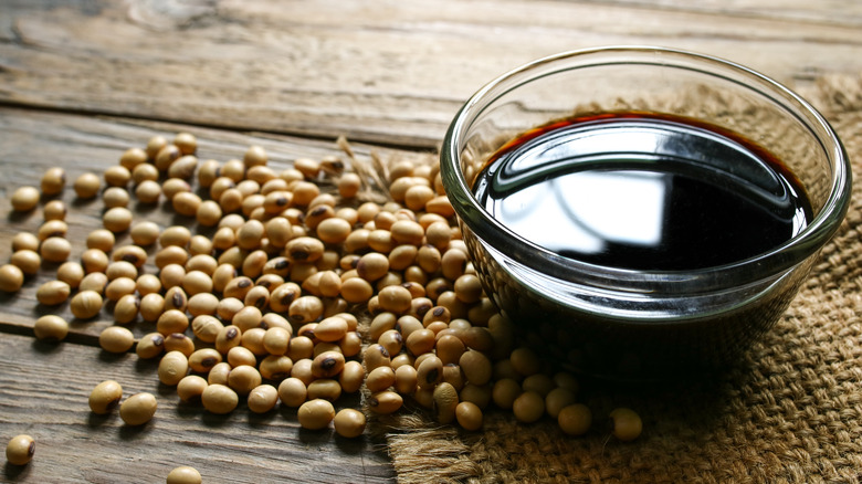 Soy sauce in a clear bowl with soy beans