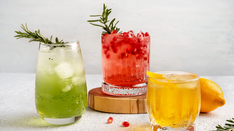 three bright cocktails, two with herb garnishes