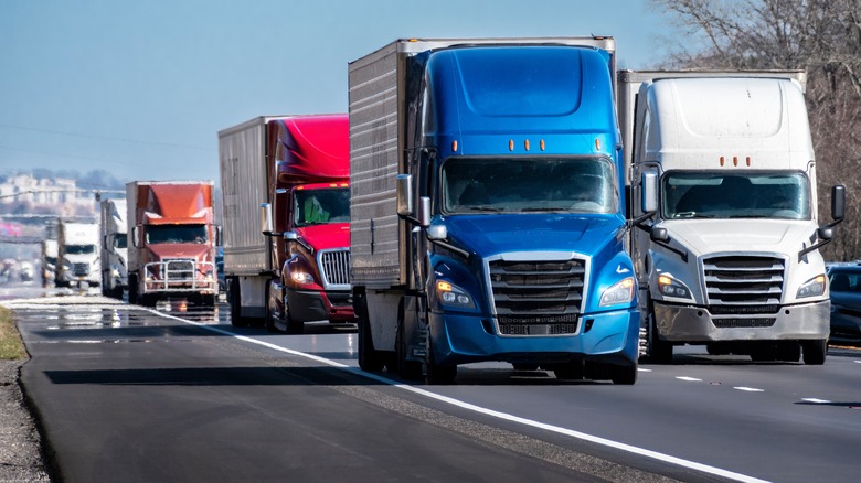 A line of 18-wheelers driving down the highway