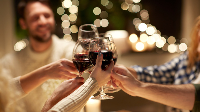 A group of friends toasting with red wine