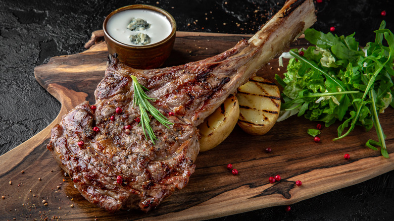 Grilled tomahawk steak on board