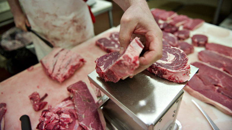 Weighing steak at butcher shop