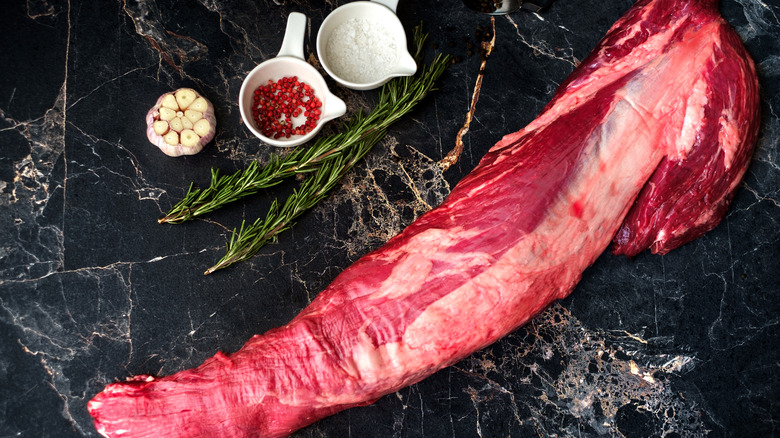 Trimmed tenderloin alongside various ingredients