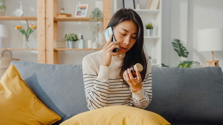 concerned woman phone with bottle