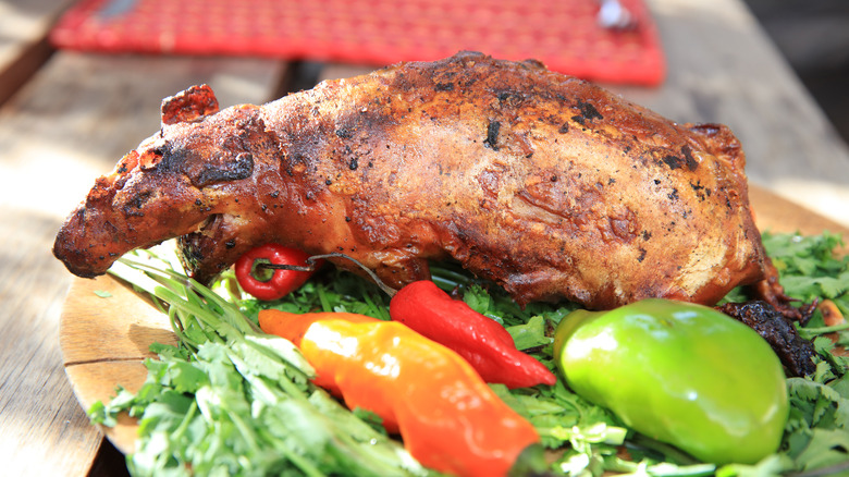 Roasted guinea pig on a plate with vegetables